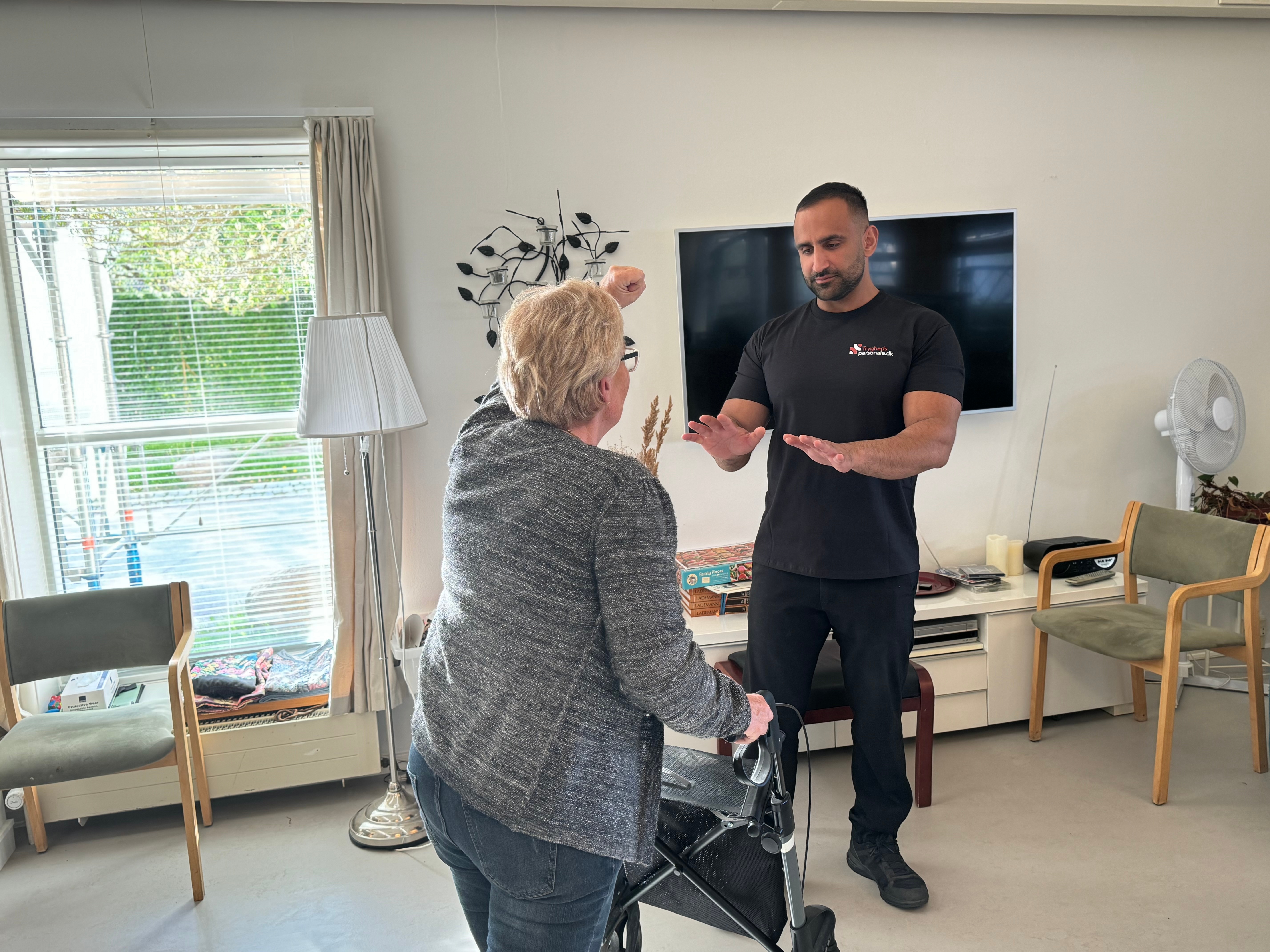 Tryghedspersonale medarbejder støtter patient i psykiatrisk miljø - professionel håndtering af udadreagerende adfærd